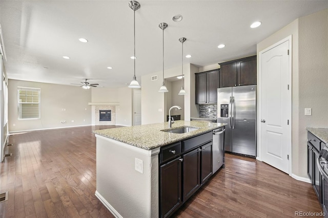 19659 W 59th Dr, Golden, CO 80403 - kitchen featuring appliances with stainless steel finishes, a ceiling fan, dark wood-type flooring, a glass covered fireplace, and recessed lighting