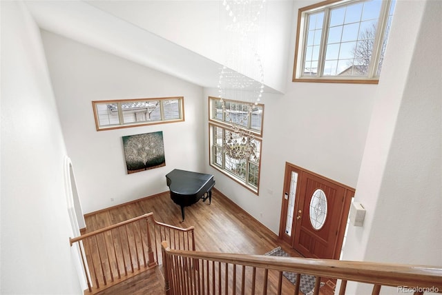 entrance foyer with a high ceiling, wood-type flooring, and an inviting chandelier