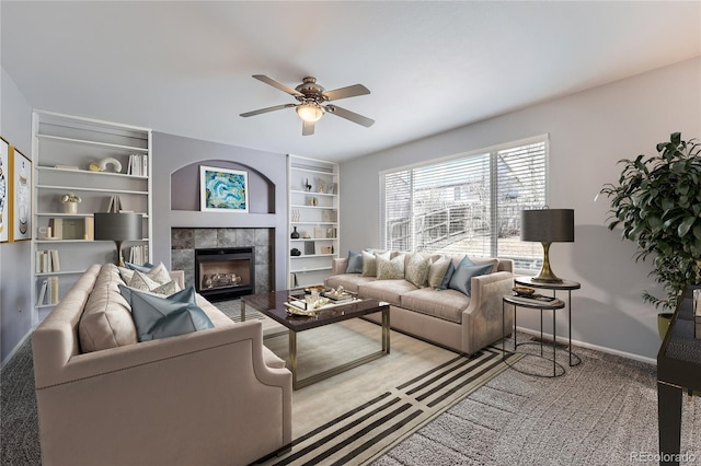 carpeted living area with a ceiling fan, a fireplace, and baseboards