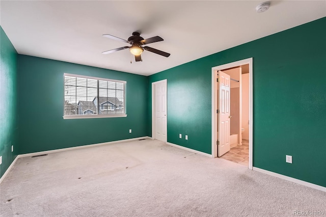 unfurnished bedroom featuring carpet, visible vents, baseboards, and ensuite bathroom