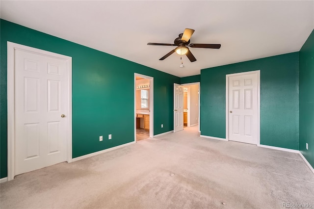 unfurnished bedroom featuring carpet floors, connected bathroom, and baseboards