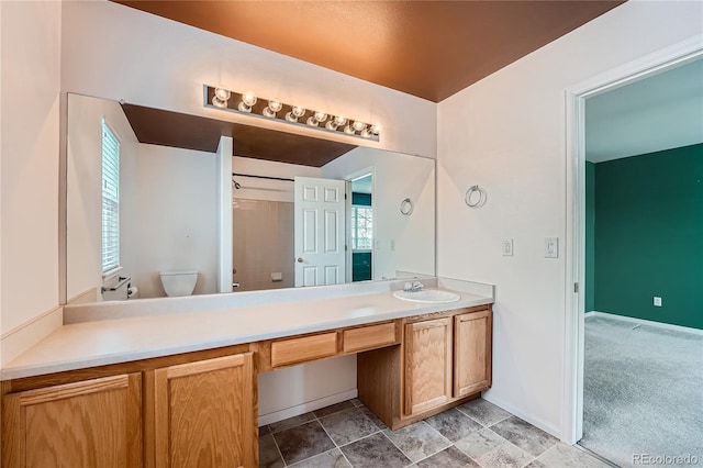 bathroom with baseboards, vanity, toilet, and walk in shower