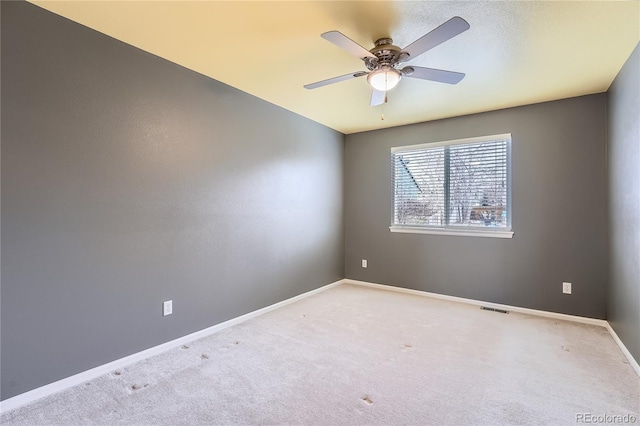 empty room featuring carpet flooring, ceiling fan, visible vents, and baseboards