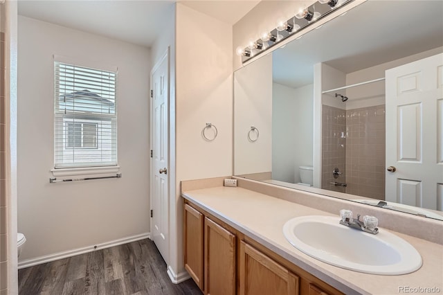 full bath featuring a shower, toilet, vanity, wood finished floors, and baseboards