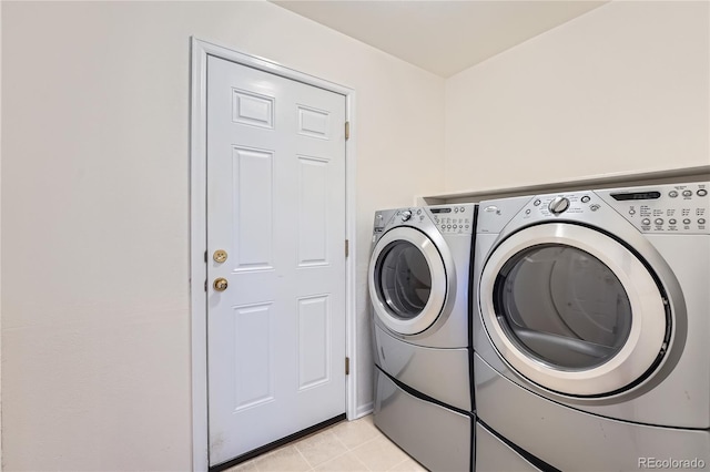 washroom featuring light tile patterned floors, laundry area, and washer and clothes dryer