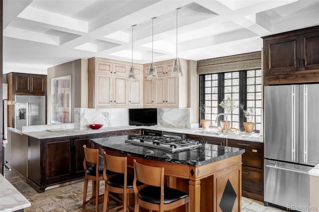 kitchen with freestanding refrigerator, gas stovetop, a center island, a sink, and decorative backsplash