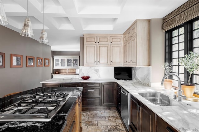 kitchen featuring tasteful backsplash, light stone counters, stone tile flooring, appliances with stainless steel finishes, and a sink