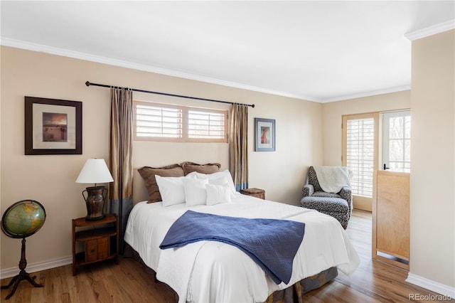 bedroom with crown molding, wood finished floors, and baseboards