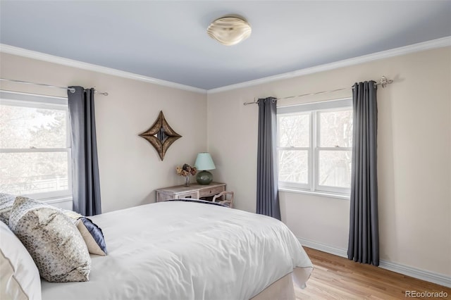 bedroom with light wood-style floors, baseboards, and ornamental molding