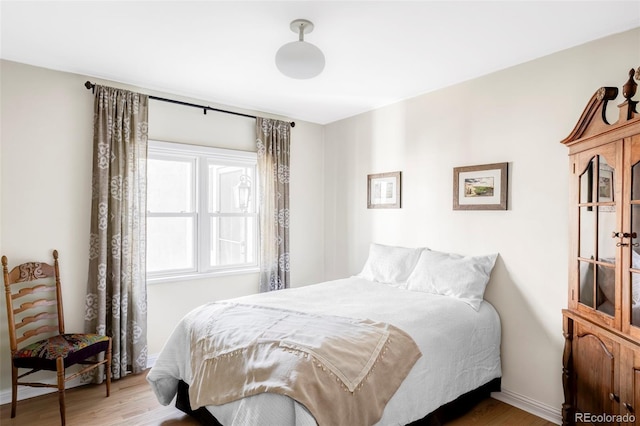 bedroom featuring baseboards and wood finished floors
