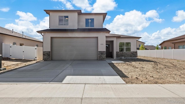 434 Clear Creek Dr, Grand Junction, CO 81504 - view of front of home with stone siding, stucco siding, concrete driveway, an attached garage, and a gate