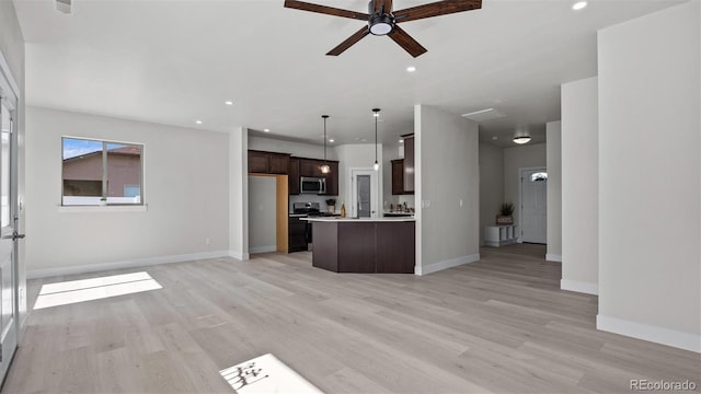 434 Clear Creek Dr, Grand Junction, CO 81504 - kitchen featuring stainless steel microwave, open floor plan, dark brown cabinetry, light wood-style floors, and recessed lighting