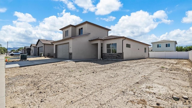 434 Clear Creek Dr, Grand Junction, CO 81504 - rear view of property with driveway, stucco siding, stone siding, and an attached garage