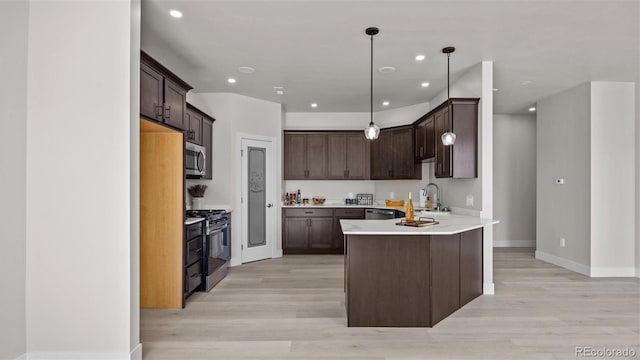 434 Clear Creek Dr, Grand Junction, CO 81504 - kitchen with appliances with stainless steel finishes, dark brown cabinetry, light wood finished floors, light countertops, and recessed lighting