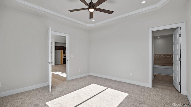 434 Clear Creek Dr, Grand Junction, CO 81504 - unfurnished bedroom featuring light colored carpet, a tray ceiling, crown molding, recessed lighting, and ensuite bath