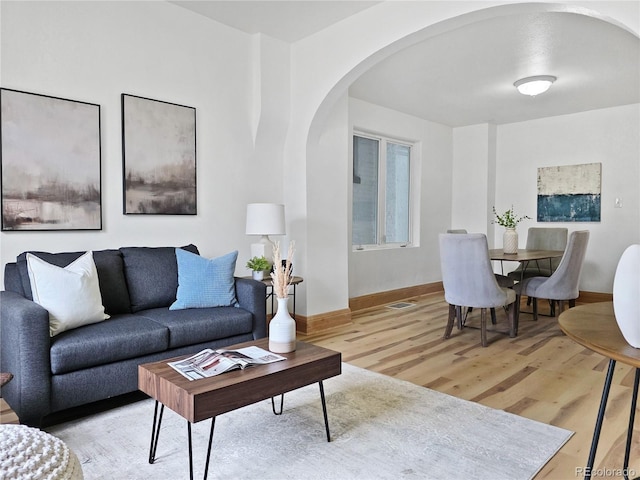 160 W Bayaud Ave, Denver, CO 80223 - living area featuring arched walkways, light wood-style floors, and baseboards