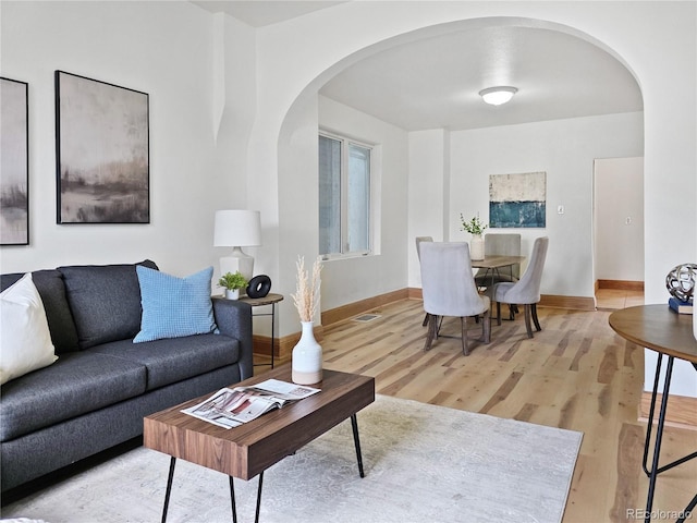 160 W Bayaud Ave, Denver, CO 80223 - living area featuring arched walkways, light wood finished floors, and baseboards