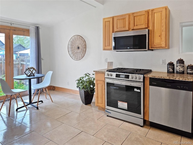 160 W Bayaud Ave, Denver, CO 80223 - kitchen featuring appliances with stainless steel finishes, light stone counters, light tile patterned floors, baseboards, and light brown cabinets
