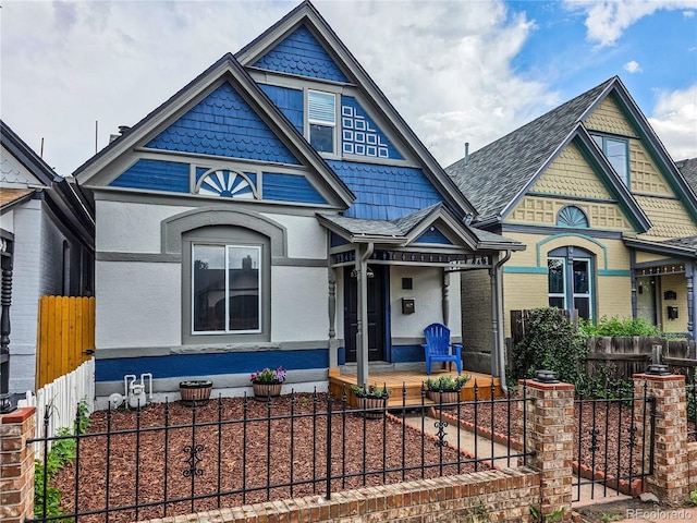 160 W Bayaud Ave, Denver, CO 80223 - victorian home featuring covered porch, a fenced front yard, stucco siding, and a gate