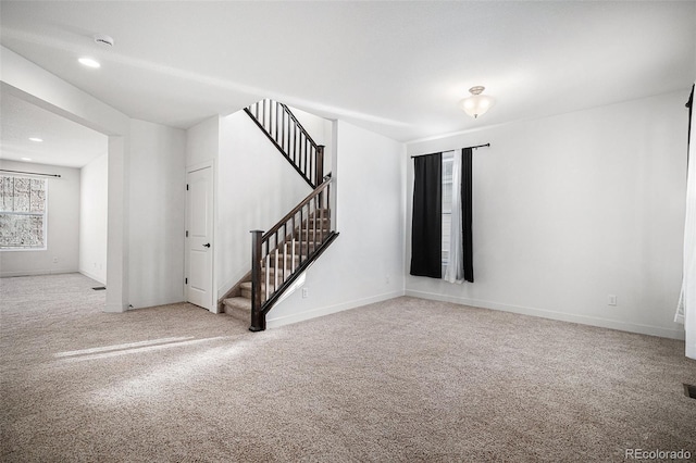 7844 S Elk St, Aurora, CO 80016 - unfurnished living room featuring carpet flooring, stairway, and recessed lighting