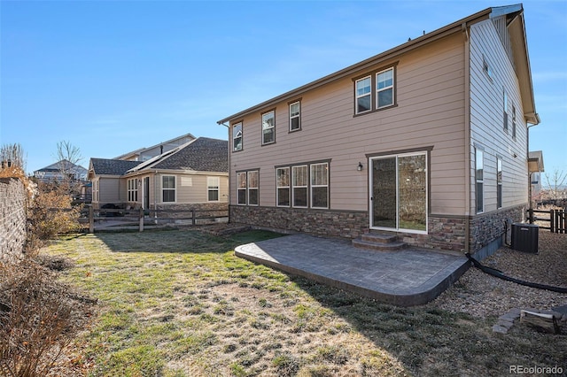 back of house featuring central AC unit, a patio area, and a lawn