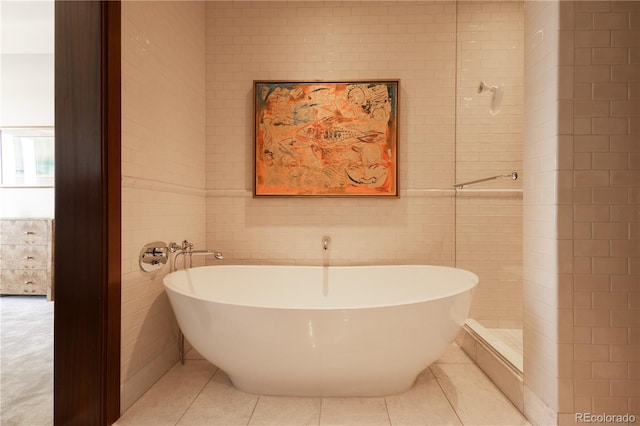 bathroom featuring independent shower and bath, tile patterned flooring, and tile walls