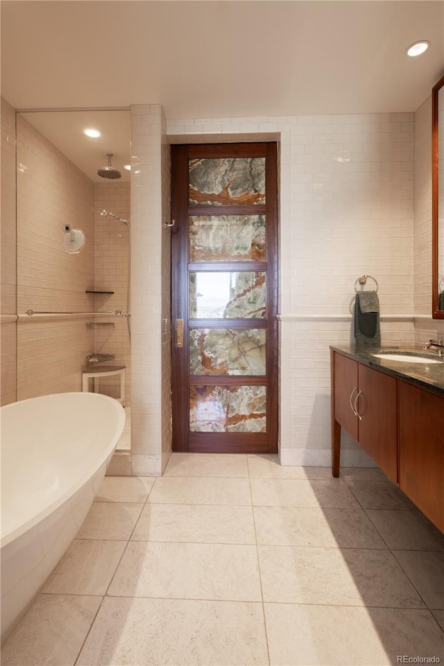 bathroom with vanity, tile patterned floors, and tile walls