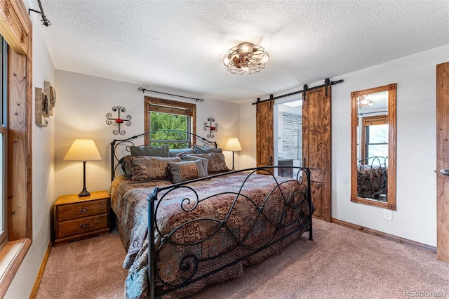 bedroom with a barn door, light carpet, and a textured ceiling