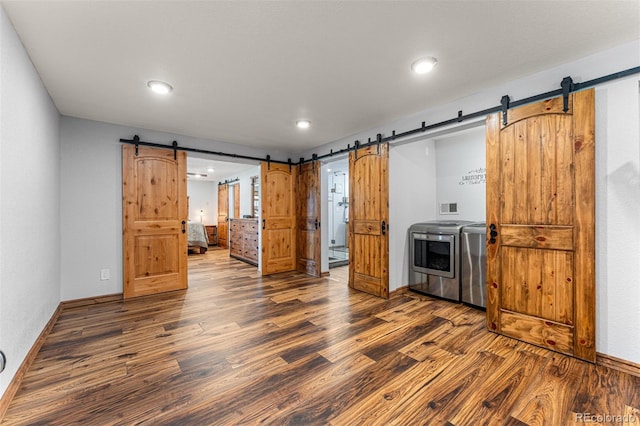 kitchen with dark wood-type flooring, a barn door, and washer / clothes dryer