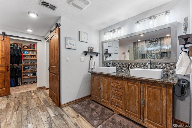 bathroom with vanity, hardwood / wood-style floors, a textured ceiling, and walk in shower