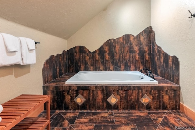 291 County Road 452, Grand Lake, CO 80447 - full bathroom featuring a textured wall, lofted ceiling, a garden tub, and a textured ceiling