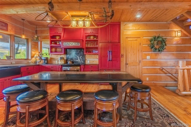 291 County Road 452, Grand Lake, CO 80447 - bar with wood ceiling with exposed beams, wooden walls, wood finished floors, a sink, and decorative light fixtures