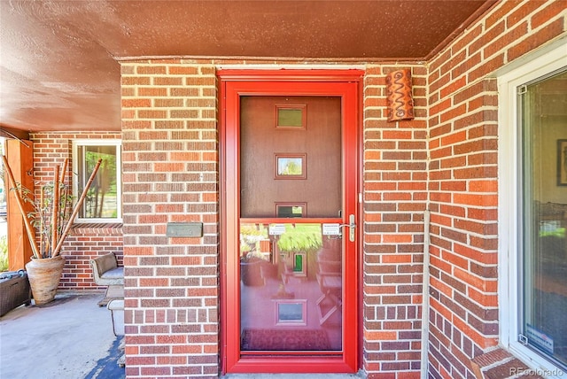 view of exterior entry with brick siding