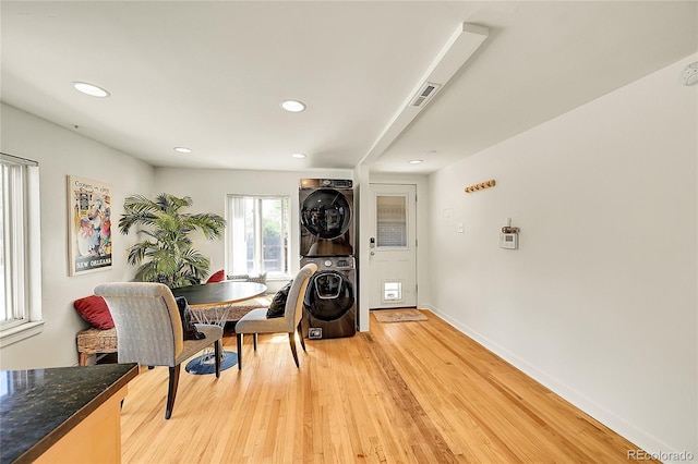 dining space with stacked washer / dryer, light wood finished floors, recessed lighting, and baseboards