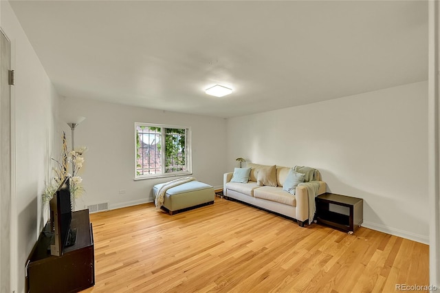 living area featuring light wood-type flooring and baseboards