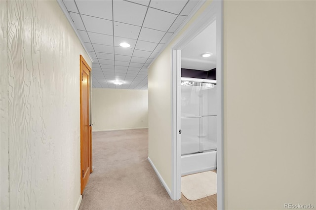 hall featuring light colored carpet, baseboards, recessed lighting, and a drop ceiling