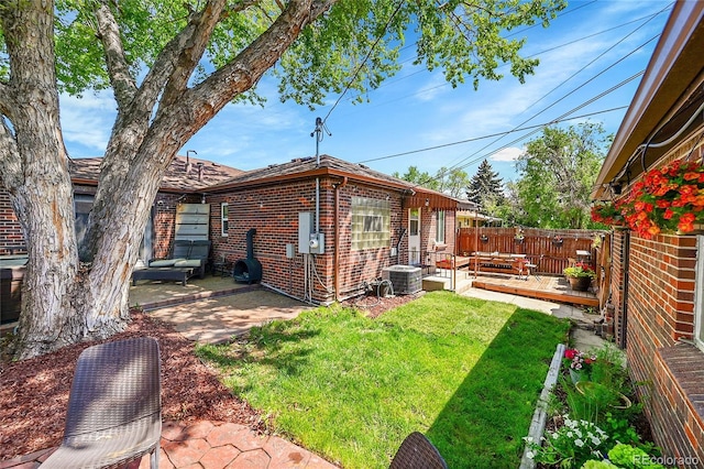 view of yard with a patio, central AC unit, and a wooden deck