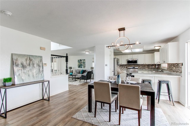 11183 E 114th Ave, Commerce City, CO 80640 - dining area featuring light wood-style floors and a chandelier