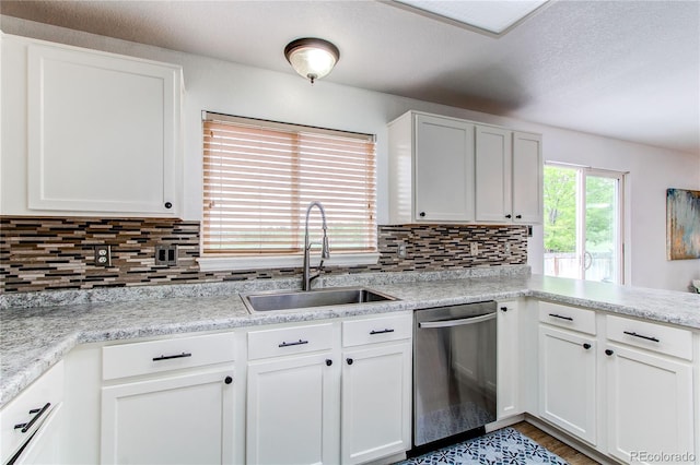 11183 E 114th Ave, Commerce City, CO 80640 - kitchen featuring dishwasher, a sink, light countertops, white cabinets, and backsplash