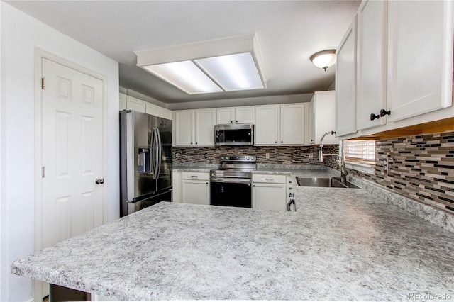11183 E 114th Ave, Commerce City, CO 80640 - kitchen featuring stainless steel appliances, a sink, decorative backsplash, white cabinets, and a peninsula