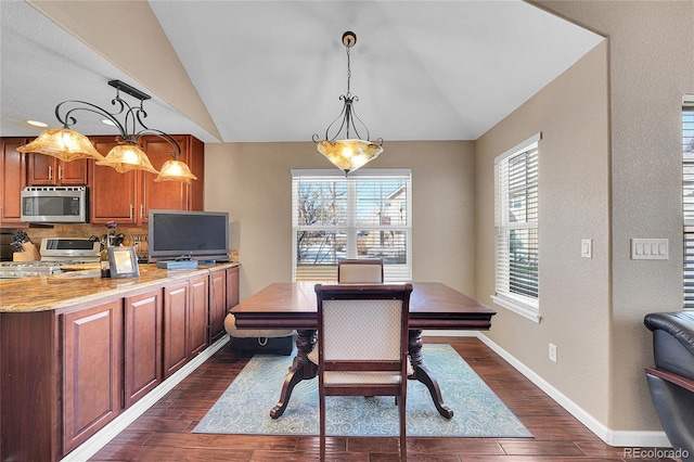 dining room with vaulted ceiling and dark wood-type flooring