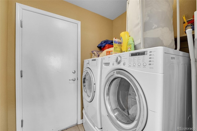 washroom with independent washer and dryer and light tile patterned flooring