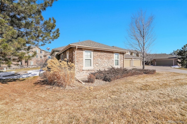 view of side of home with a garage and a lawn