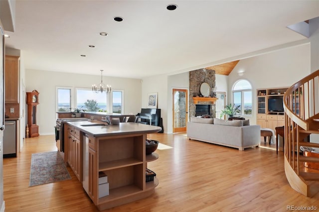 kitchen featuring lofted ceiling with beams, a kitchen island with sink, sink, and light hardwood / wood-style floors