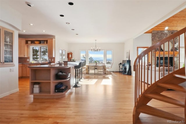 kitchen with hanging light fixtures, plenty of natural light, light hardwood / wood-style floors, and a notable chandelier