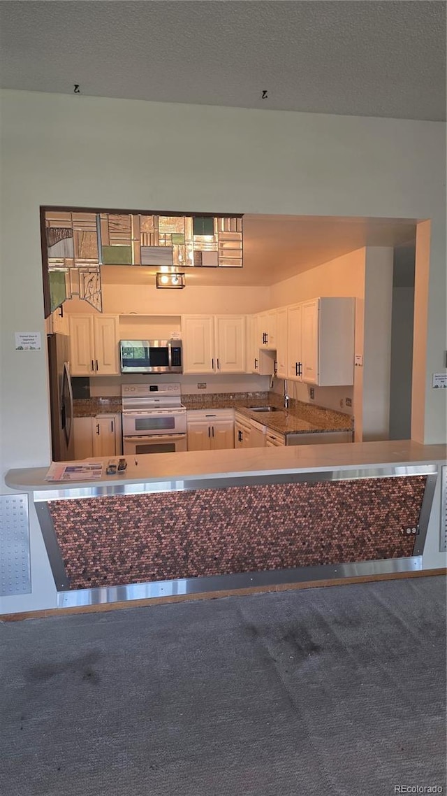 775 S Alton Way Unit 3D, Denver, CO 80247 - kitchen with appliances with stainless steel finishes, dark countertops, and white cabinetry