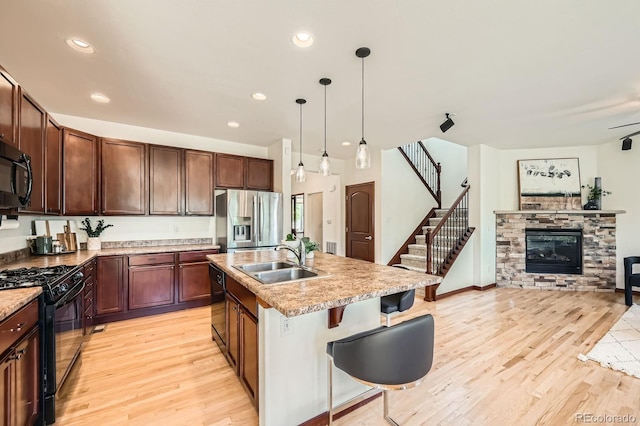 2150 Wagon Way, Louisville, CO 80027 - kitchen featuring black appliances, a sink, light wood-style flooring, open floor plan, and recessed lighting