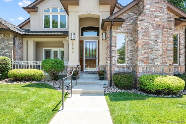 222 S Olive St, Denver, CO 80230 - view of exterior entry featuring stucco siding and a lawn
