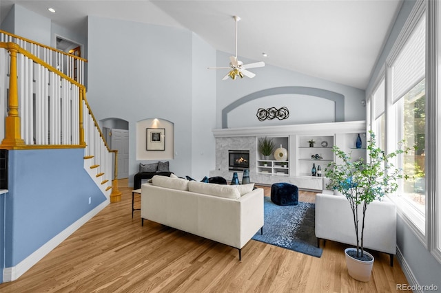 222 S Olive St, Denver, CO 80230 - living room featuring a ceiling fan, stairway, wood finished floors, a glass covered fireplace, and high vaulted ceiling