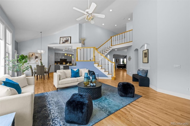 222 S Olive St, Denver, CO 80230 - living area featuring stairway, wood finished floors, high vaulted ceiling, a ceiling fan, and arched walkways